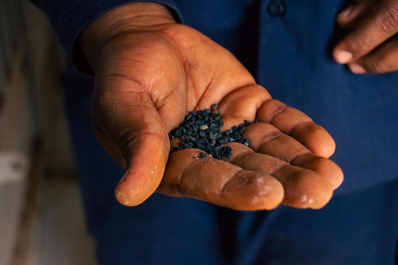 A miner's open hand holding freshly mined gold ore.